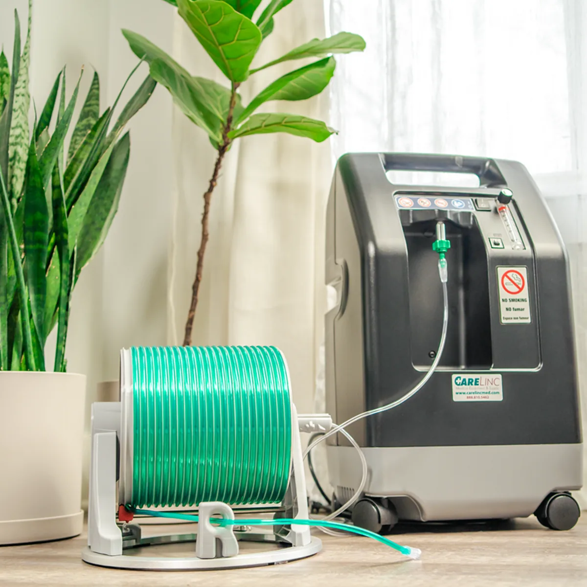 Buddy™ Retractable Oxygen Tubing Reel next to a home oxygen concentrator
